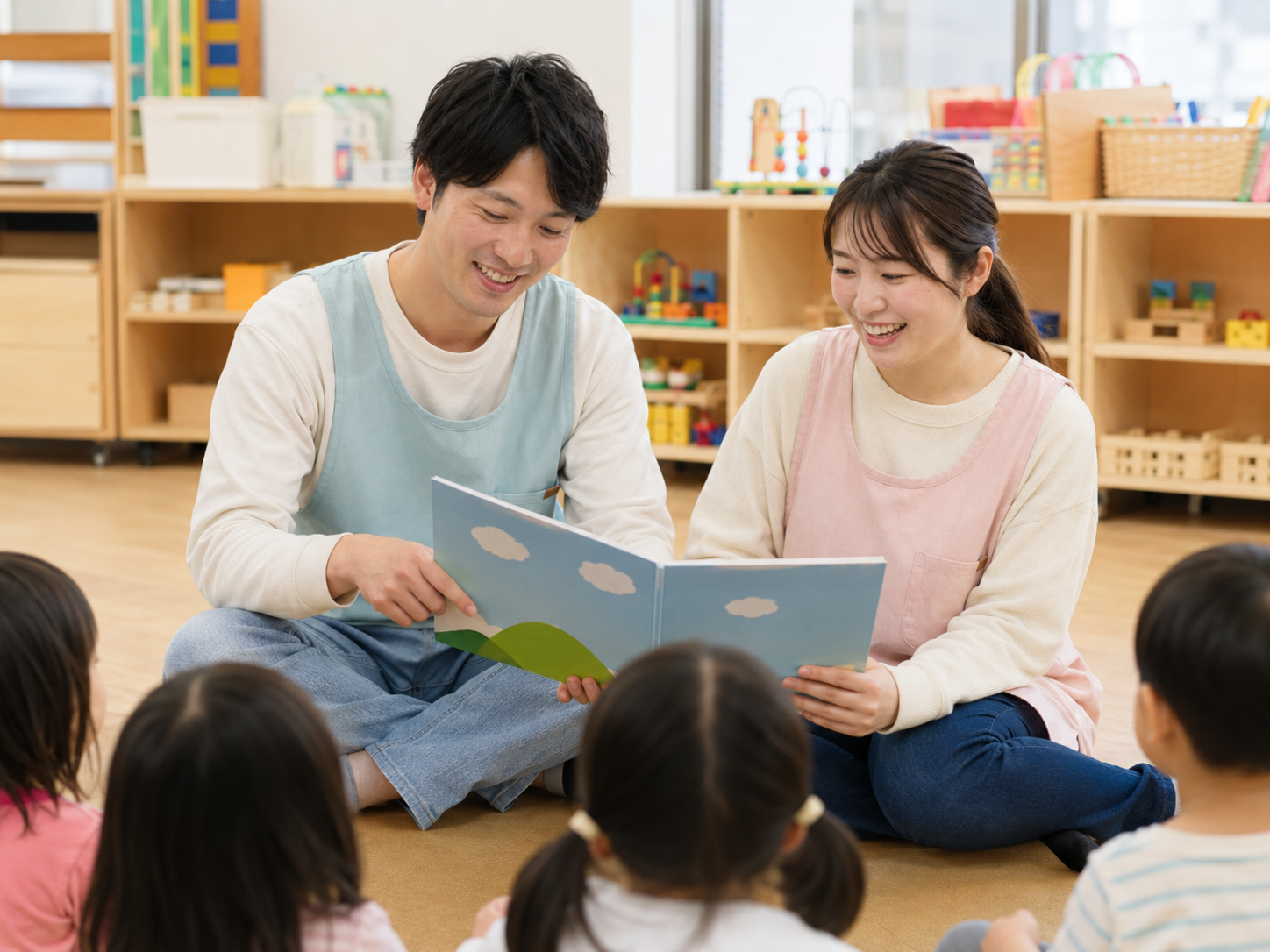 絵本を読み聞かせる保育士と子どもたち